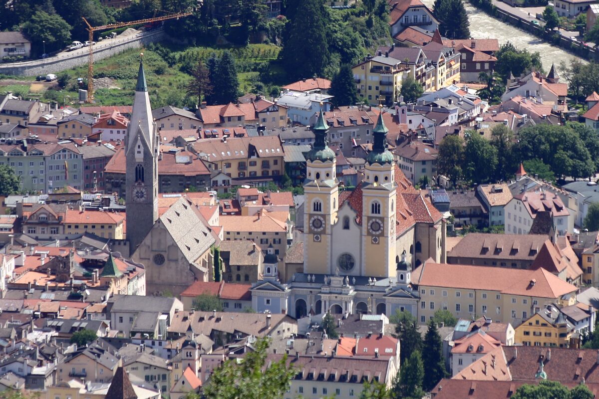 The old town of Brixen seen from above, with the twin towers of the cathedral and the red roofs of the town center
