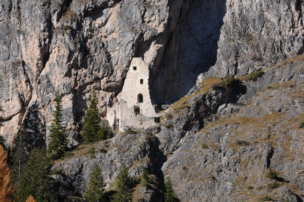 The ruin of Wolkenstein Castle built into the rock face of the Langental valley near Selva
