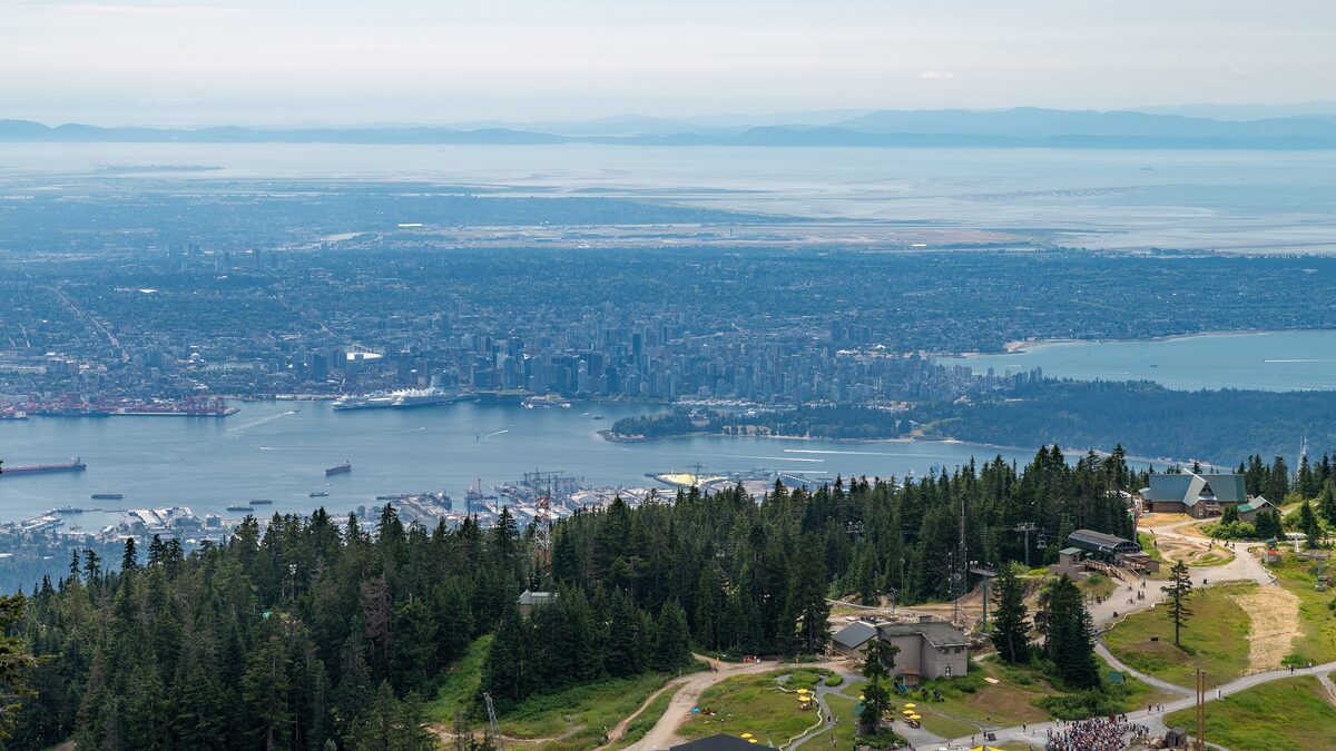 View from Grouse Mountain over the forested slope to downtown Vancouver, the harbor and the Strait of Georgia