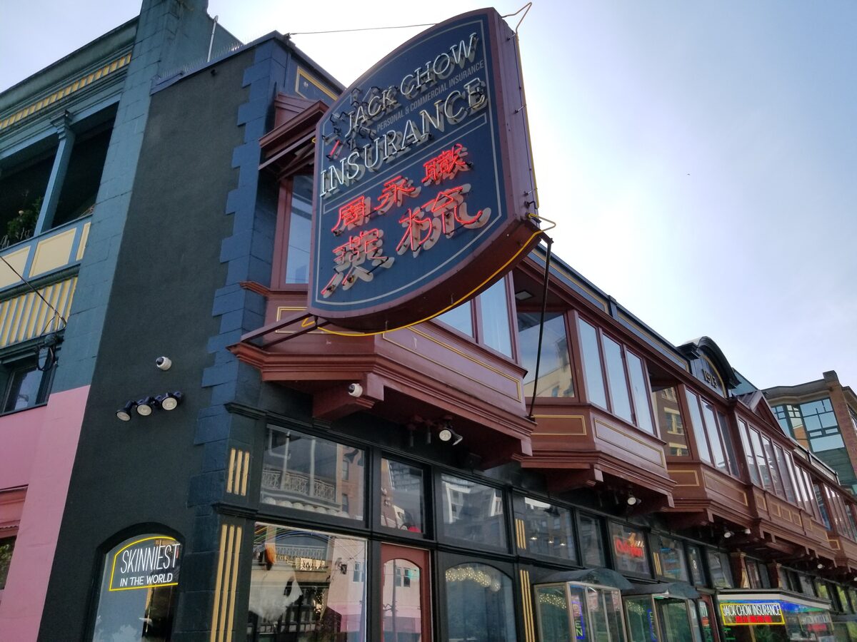 The narrow Sam Kee Building on Pender Street with its red bay windows and the Jack Chow Insurance sign