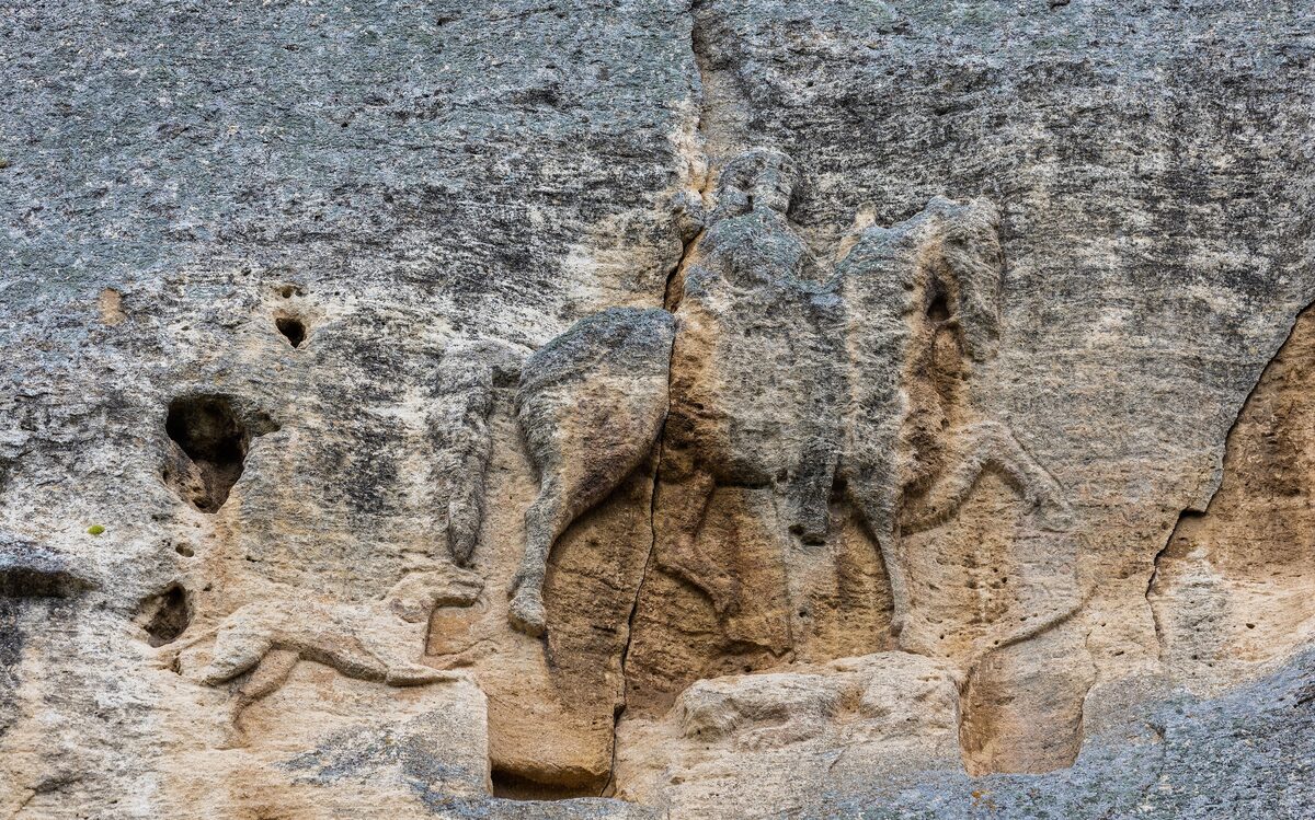Close view of the Madara Rider relief: a horseman carved into the cliff, with a dog running behind and a lion beneath the horse.