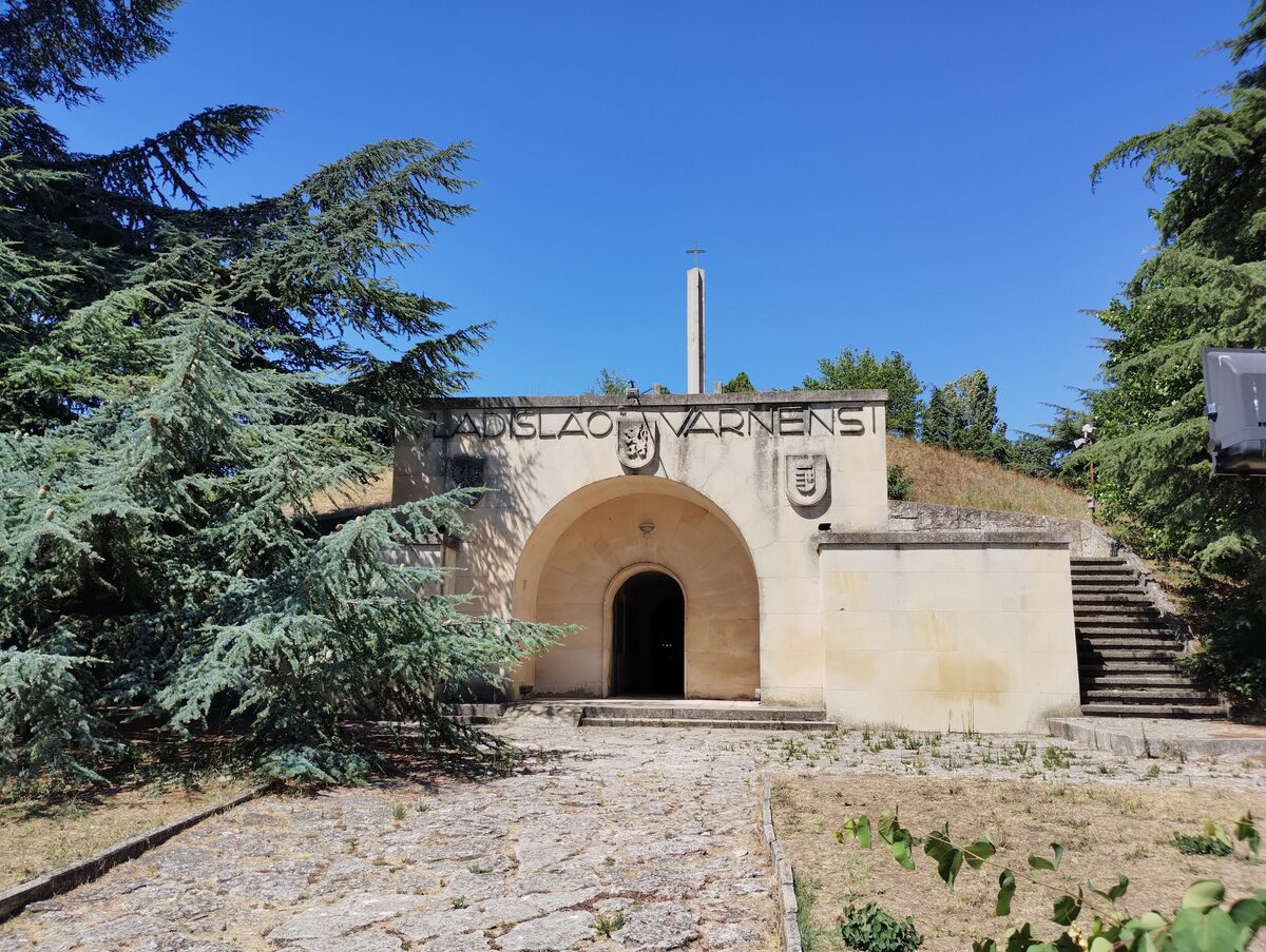The arched stone entrance of the Vladislav Varnenchik mausoleum, inscribed LADISLAO VARNENSI, built into a burial mound with a cross on top.