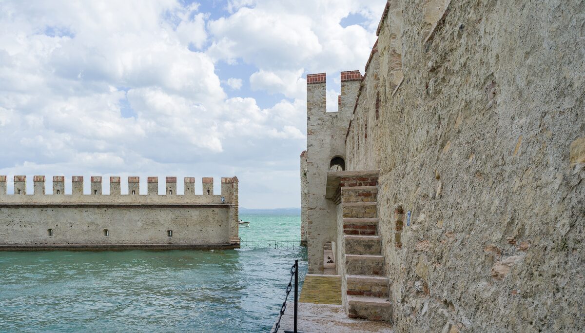 The battlemented walls of the Scaliger castle rising straight out of Lake Garda