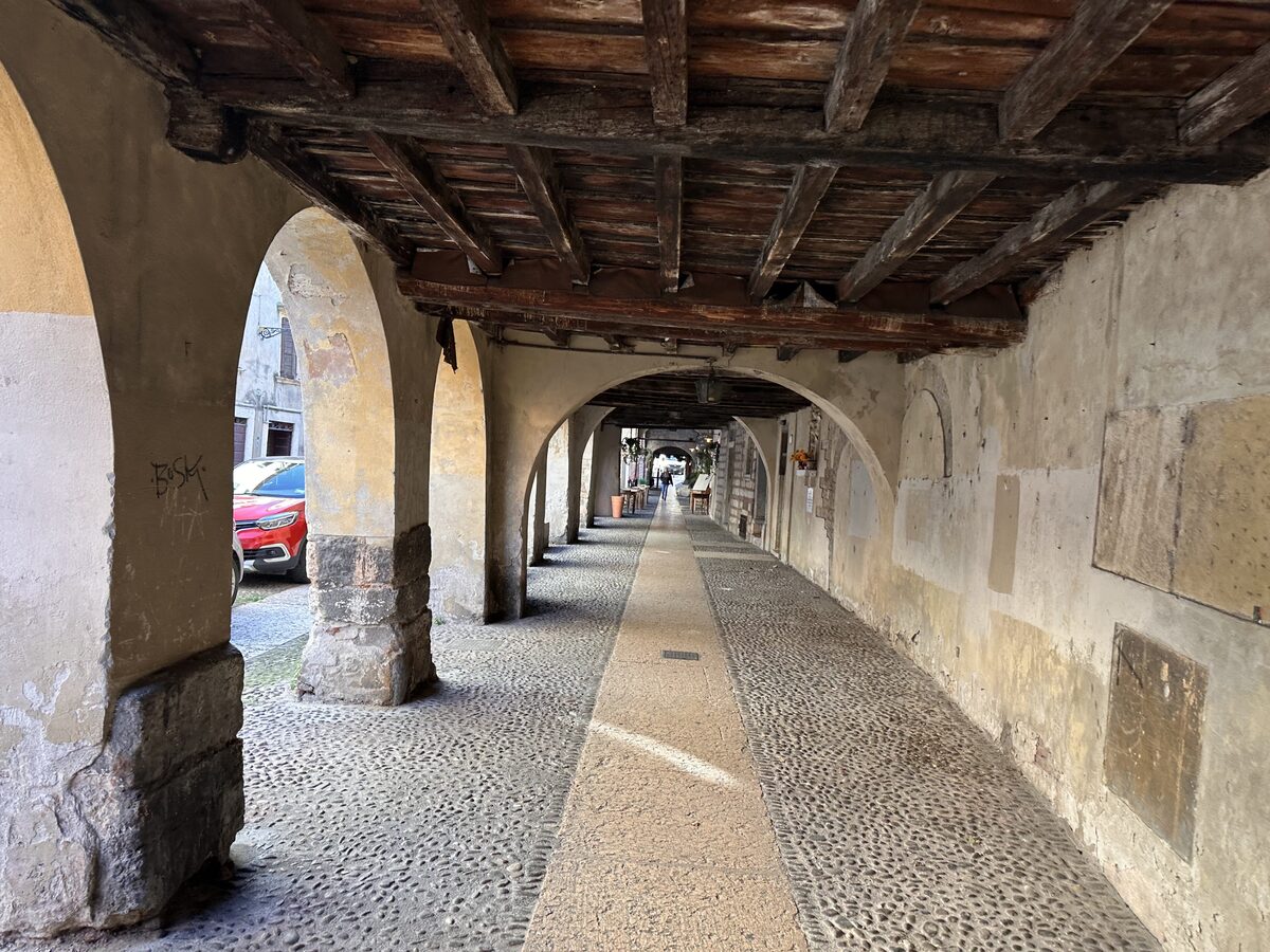 The medieval arcade of Via Sottoriva with its wooden ceiling