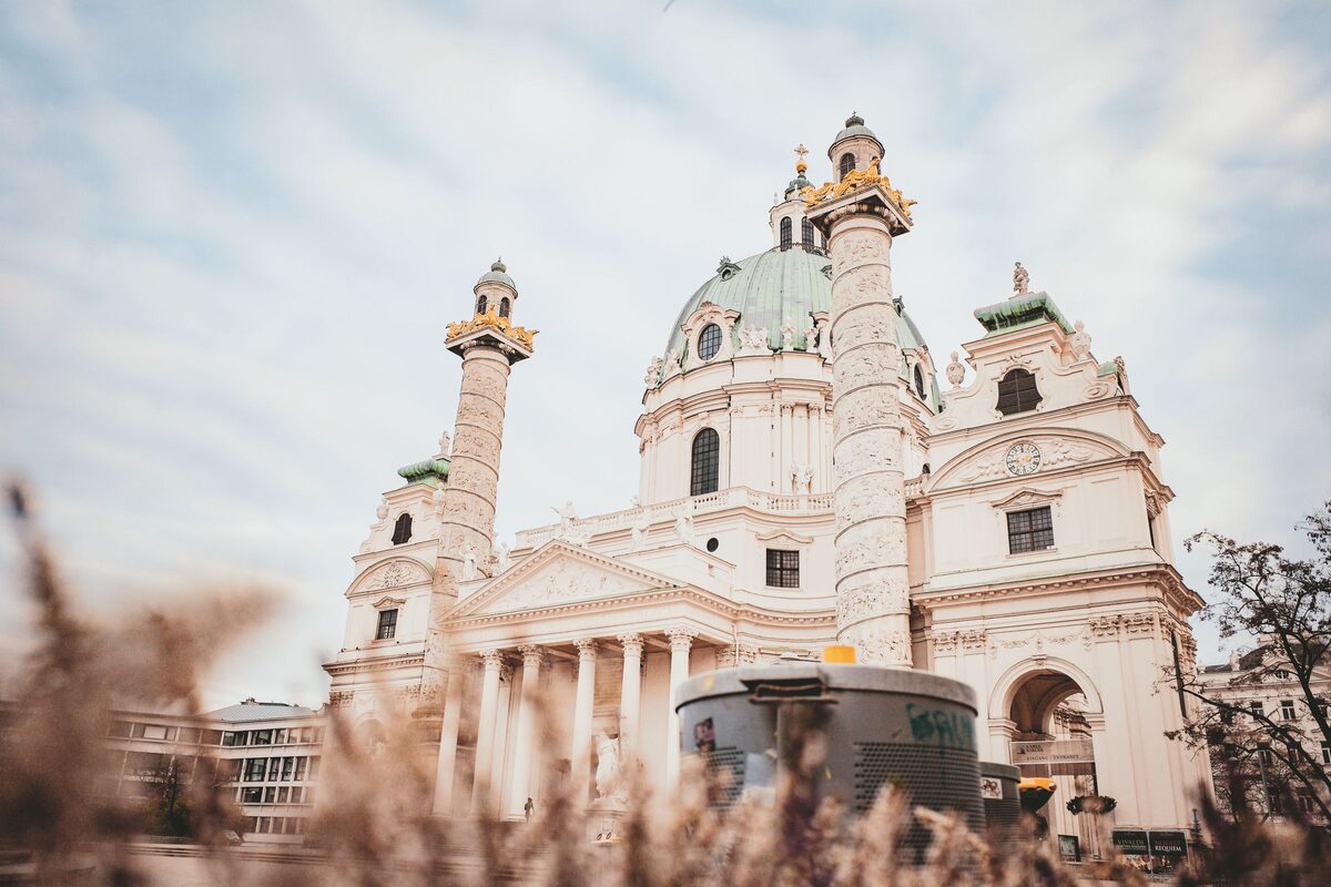The baroque Karlskirche in Vienna with its green dome and two tall columns covered in reliefs