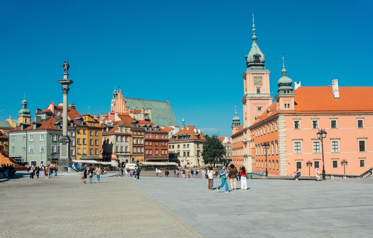 Castle Square in Warsaw with Sigismund's Column, the pink Royal Castle and its clock tower, and the Old Town houses behind