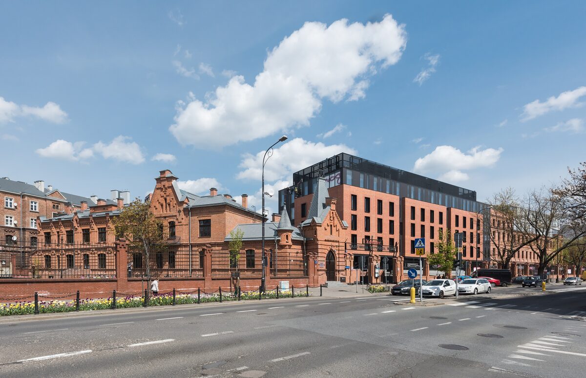 The red brick buildings of the old Koneser vodka distillery on Ząbkowska street, with a new block behind