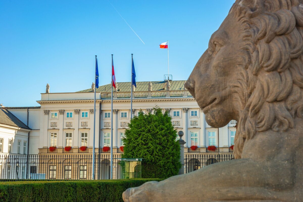The Presidential Palace on Krakowskie Przedmieście behind its gates, with a stone lion in the foreground