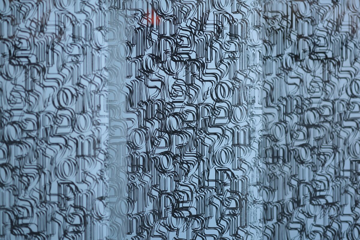 Detail of the POLIN Museum facade, glass panels printed with layers of Latin and Hebrew letters