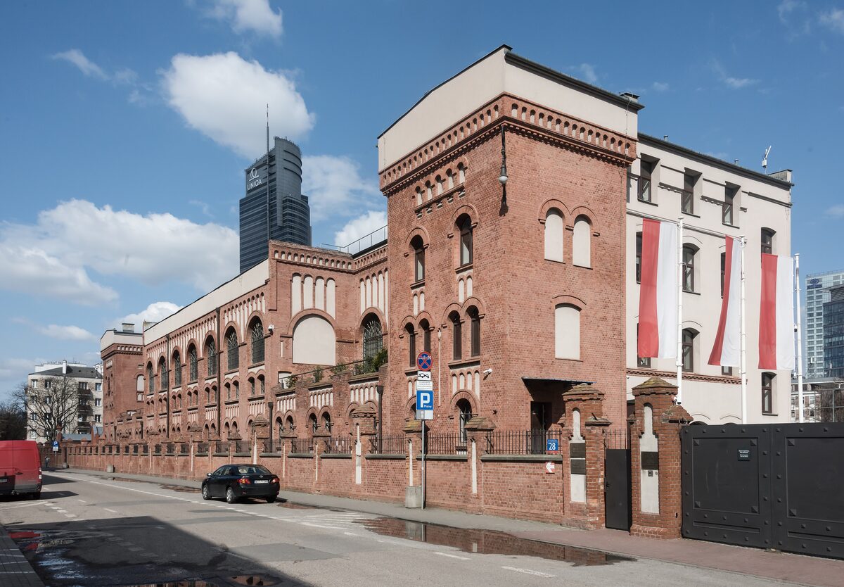 The red brick tram power station that houses the Warsaw Rising Museum, with a skyscraper behind