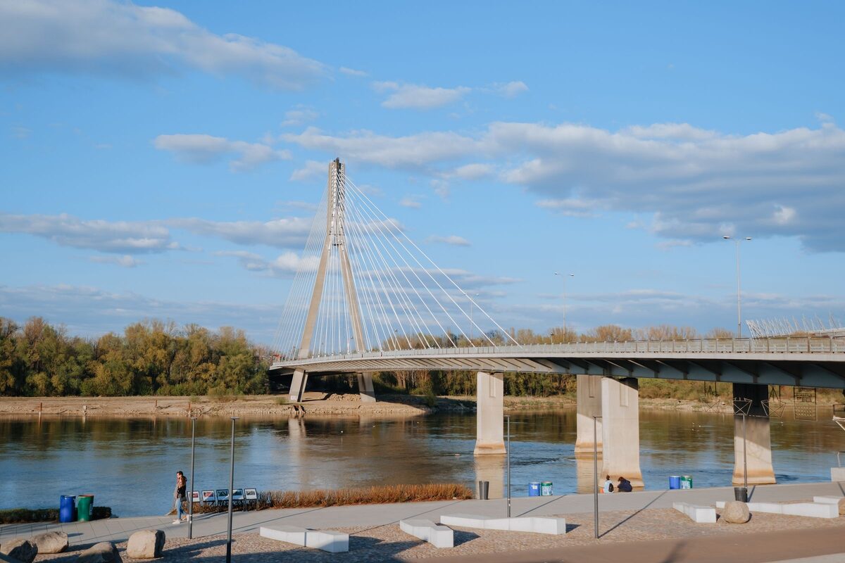The Vistula Boulevards in Warsaw on a sunny day, with the white pylon of the Świętokrzyski Bridge