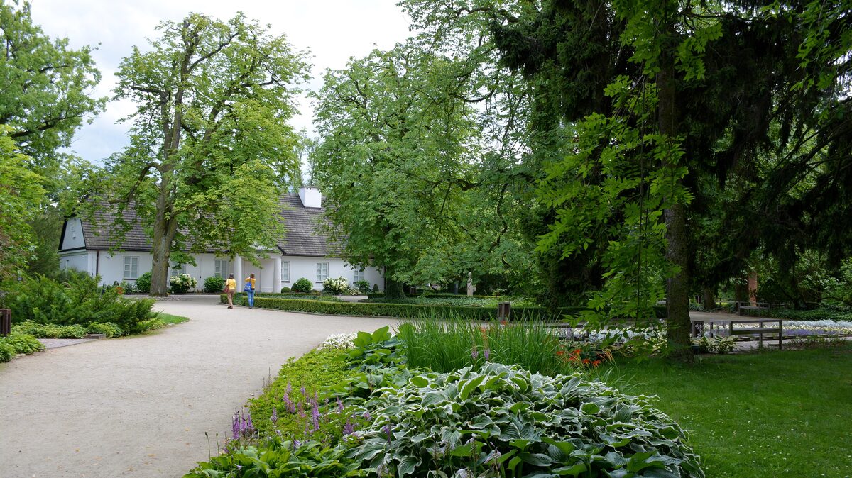 The white manor house at Żelazowa Wola where Chopin was born, behind a garden path and trees