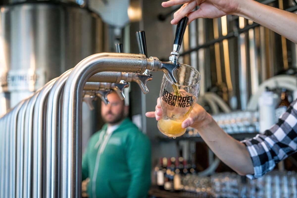 A tap pouring beer into a glass in a brewery