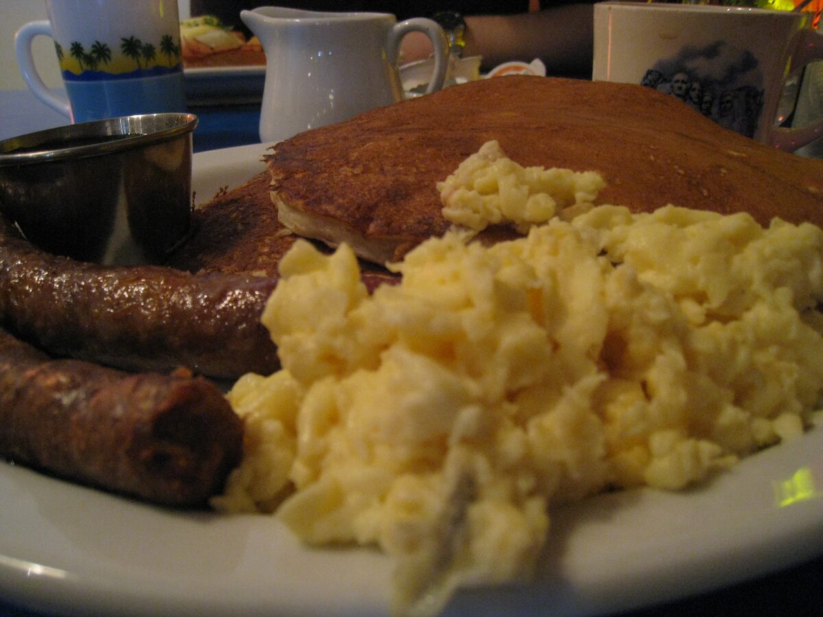 Pancakes, scrambled eggs and sausage on a diner plate