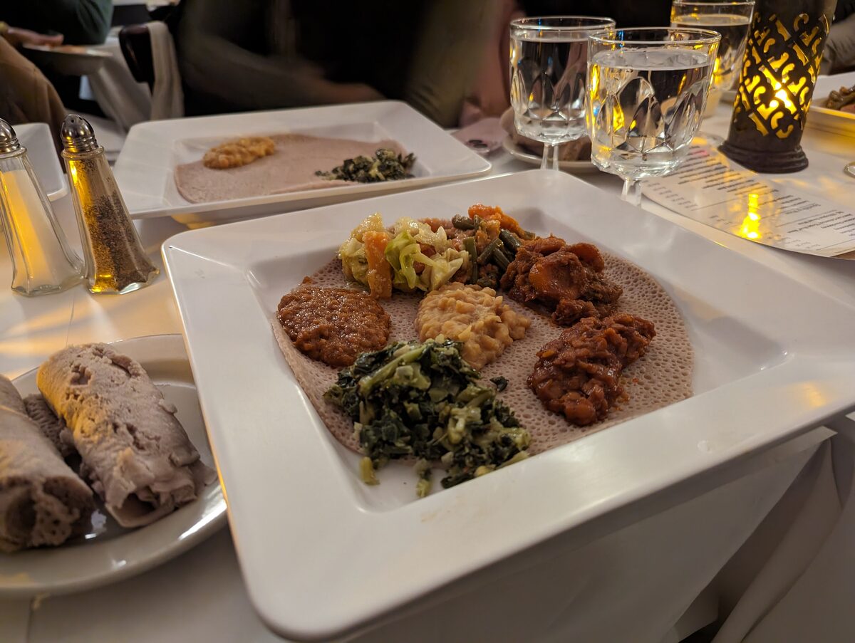 Injera platter with stews and greens at an Ethiopian restaurant