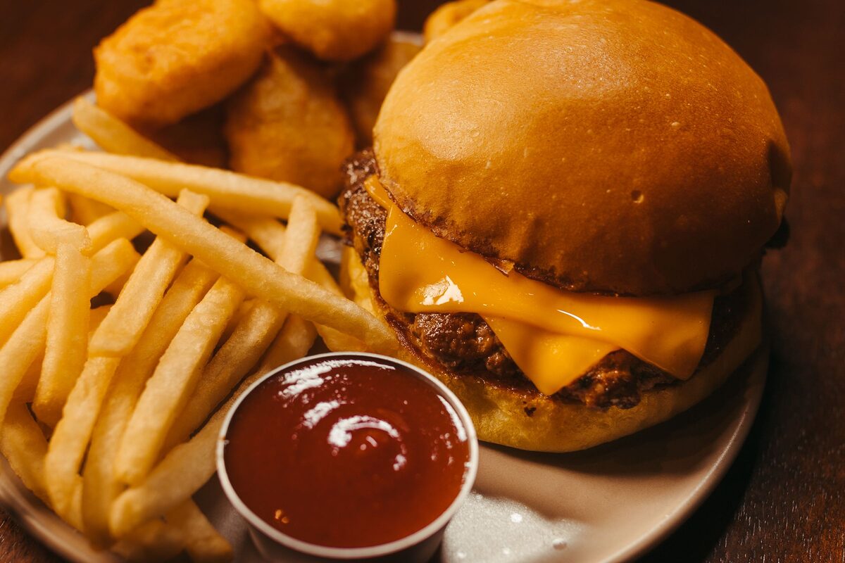 A cheeseburger with fries and ketchup on a plate