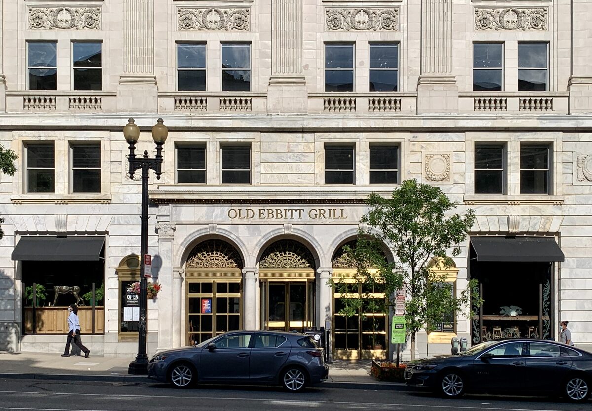 Arched entrance of Old Ebbitt Grill on a stone downtown building