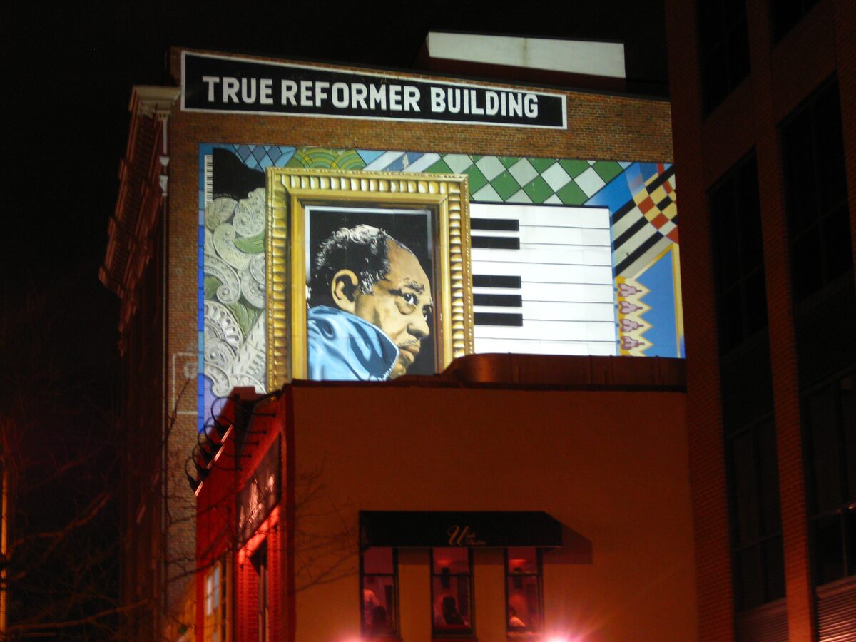 Duke Ellington mural on the True Reformer Building at night