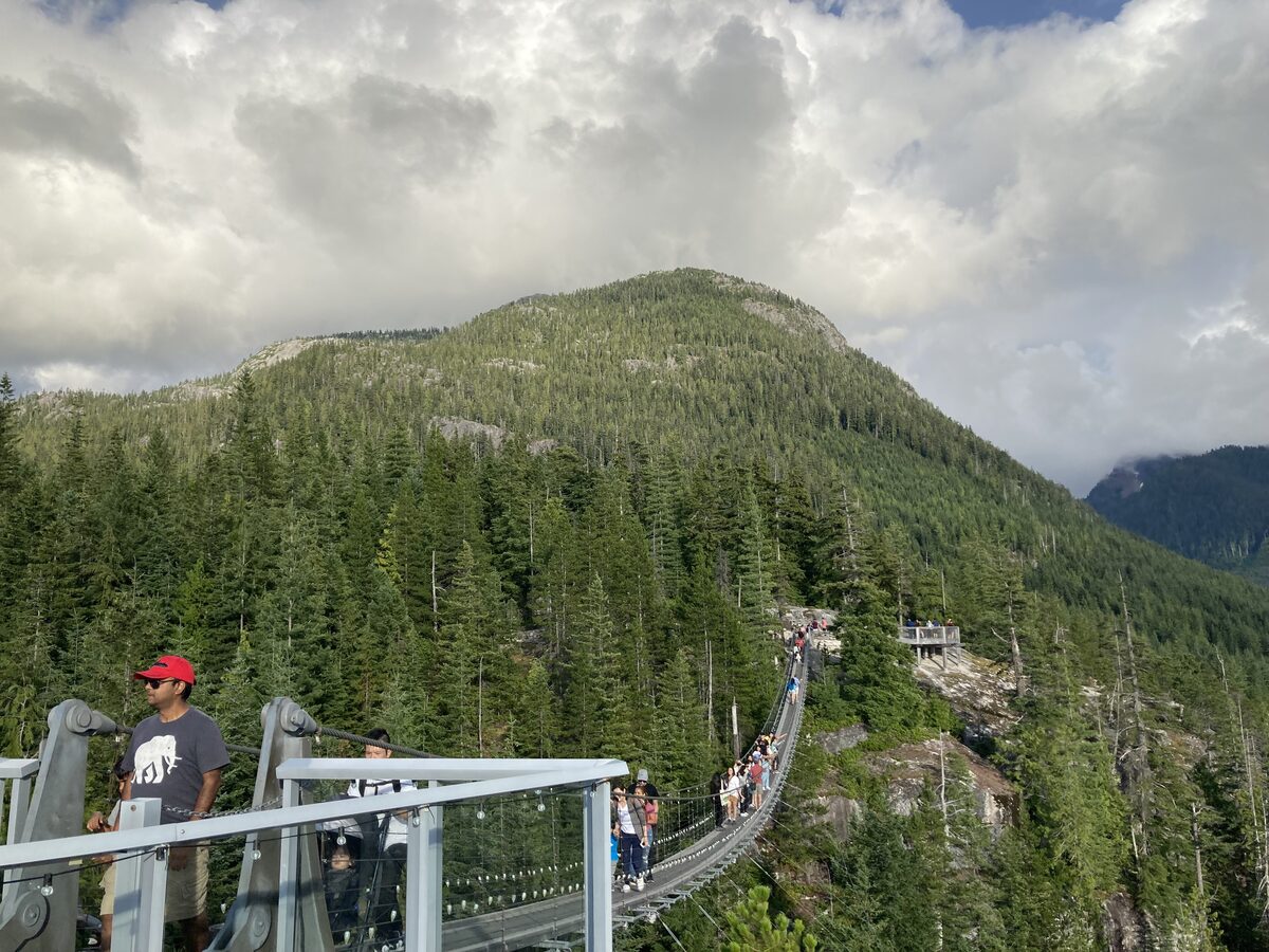 Visitors on the Sky Pilot suspension bridge above forested mountains at the Sea to Sky Gondola summit