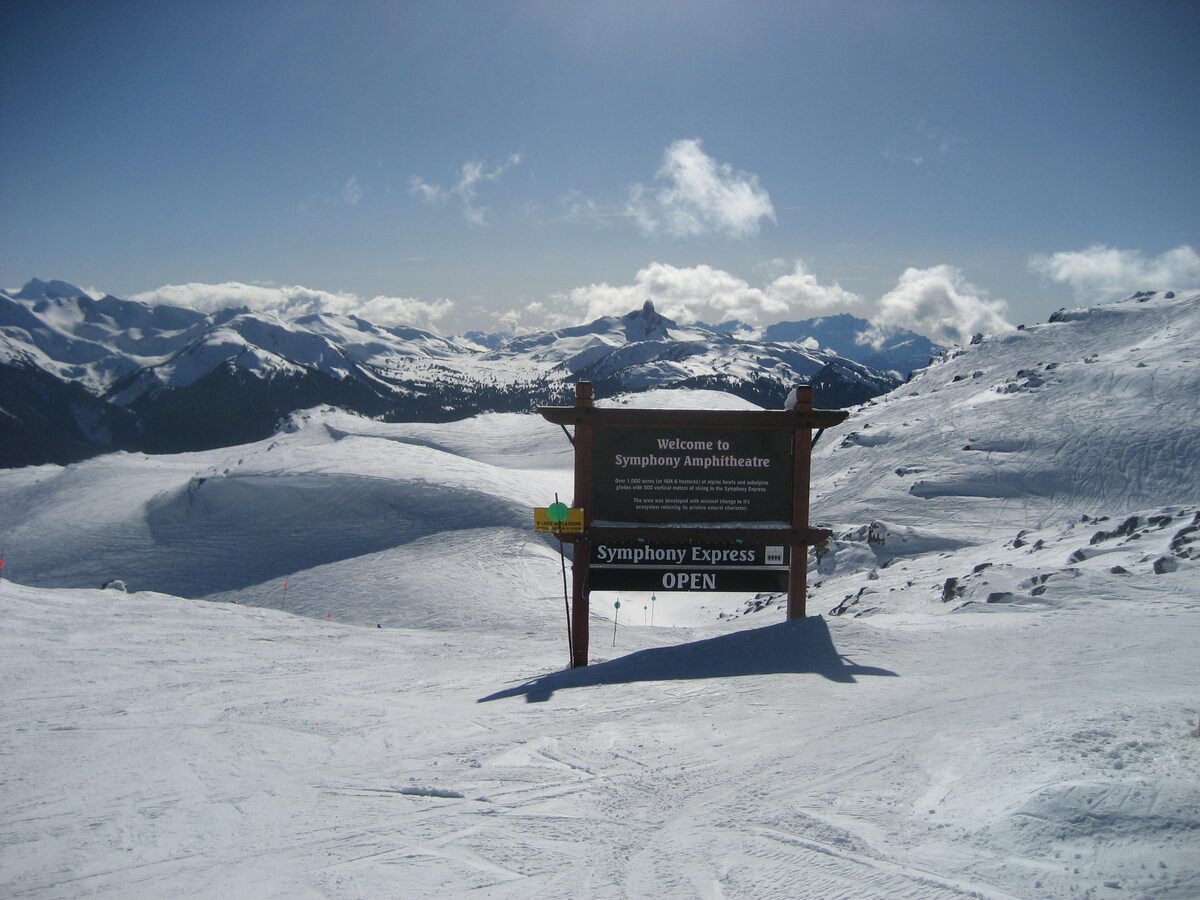 The Symphony Amphitheatre sign in deep snow with the Coast Mountains behind
