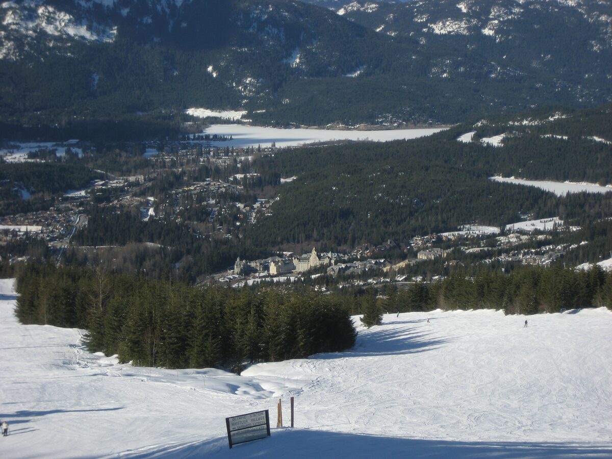 A snowy run leading down toward the Upper Village and Whistler valley seen from Blackcomb Mountain