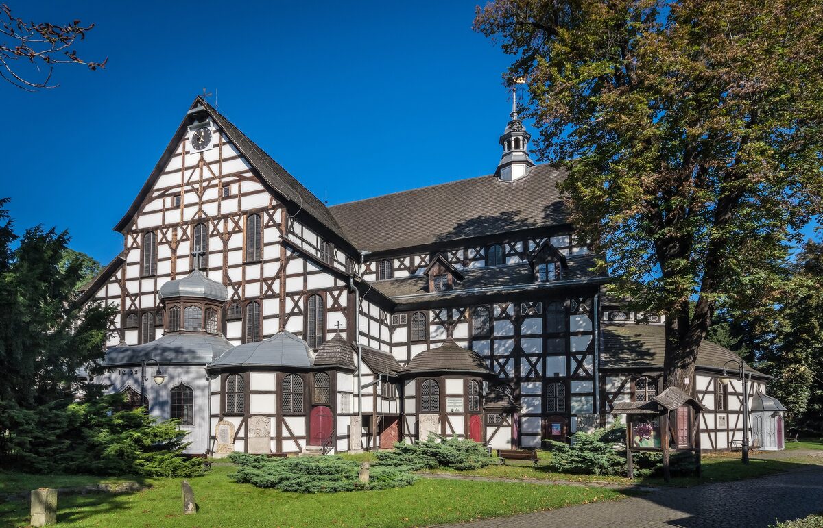 The half-timbered Church of Peace in Świdnica among trees and green bushes