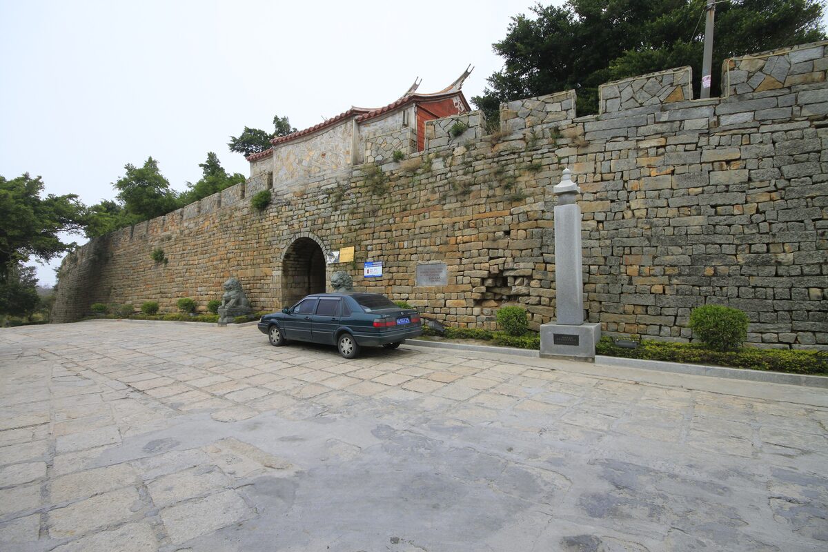 A stretch of Chongwu's granite city wall with a gate arch and a small tower on top