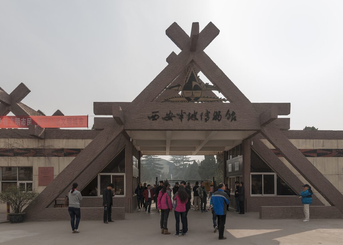The A-frame timber entrance gate of the Banpo Museum, with visitors walking in