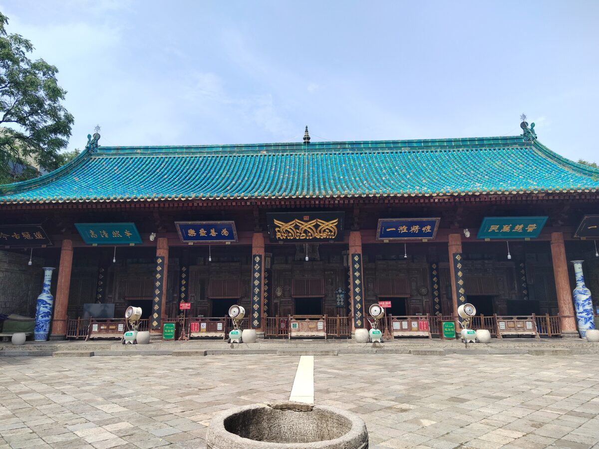 The prayer hall of the Great Mosque of Xi'an, a wide Chinese-style hall with a blue-green tiled roof behind a paved courtyard
