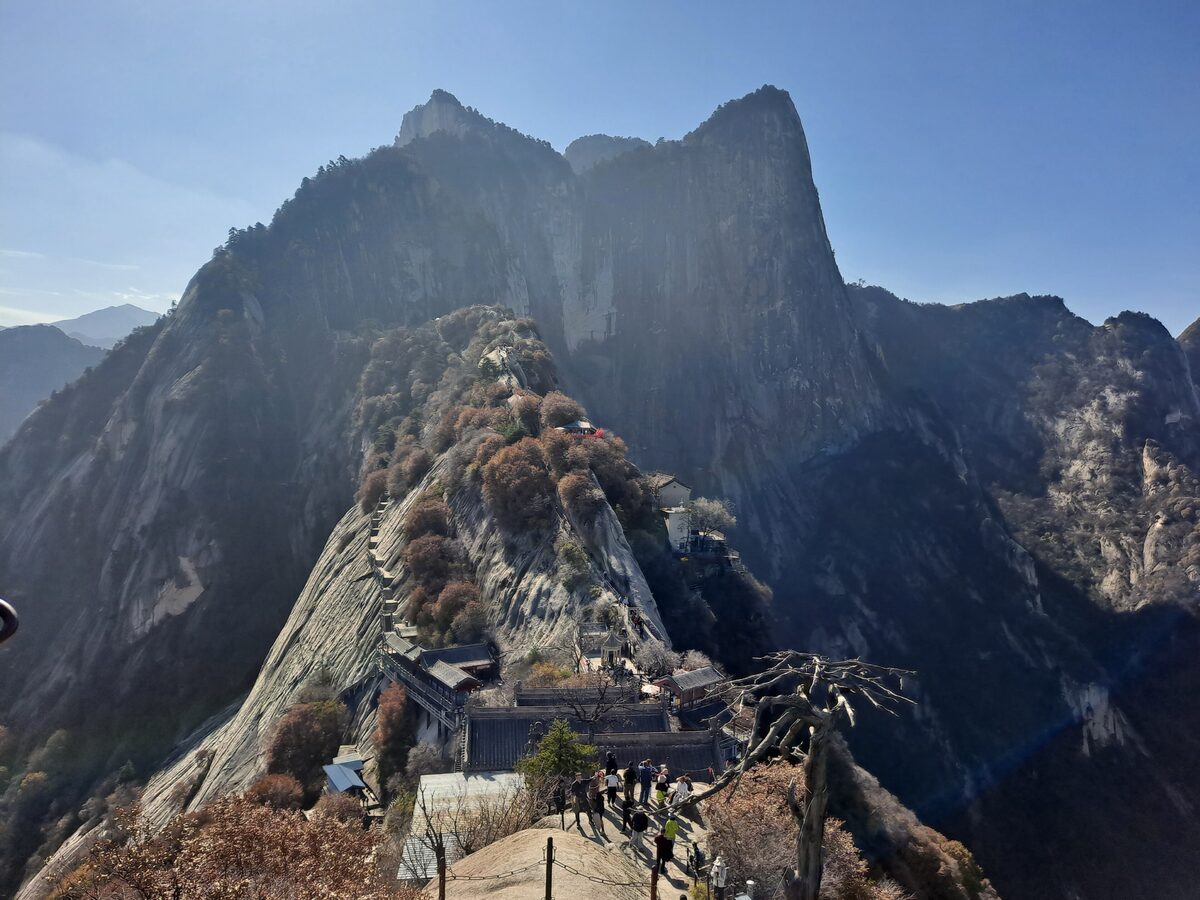 The sheer granite ridge of Mount Hua's North Peak, with a small temple tucked into the rock below the summit