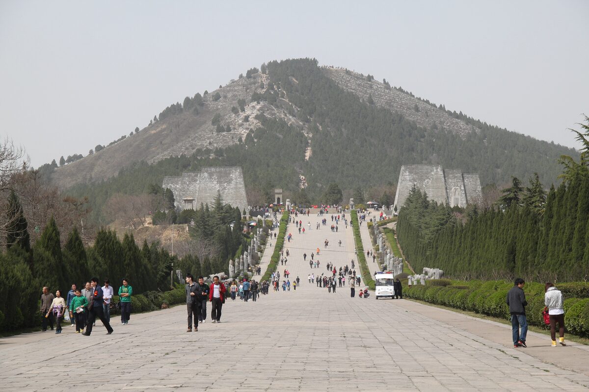The broad stone spirit way climbing toward the hill of Qianling Mausoleum, with visitors walking along it
