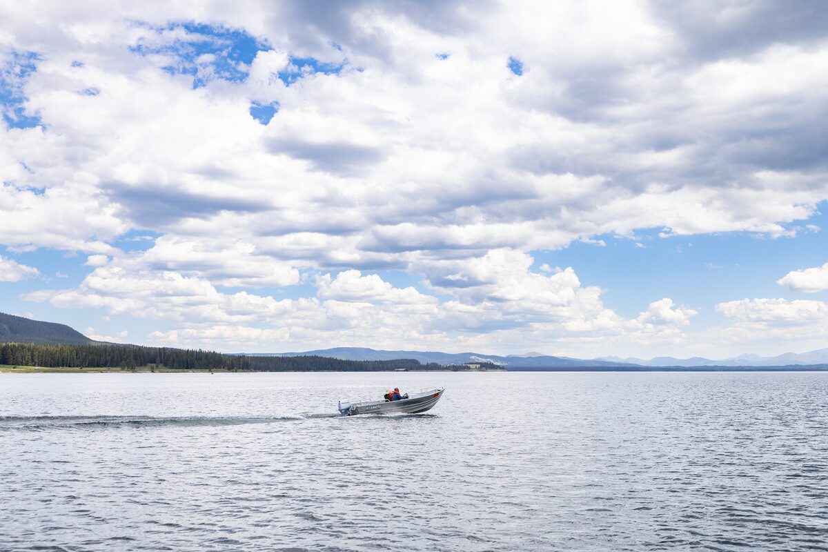 A small boat crossing Yellowstone Lake under broad clouds