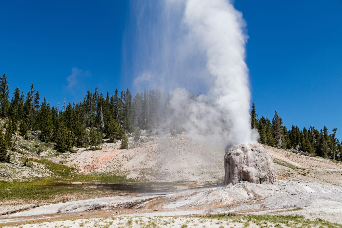 Lone Star Geyser erupting from its cone under blue sky
