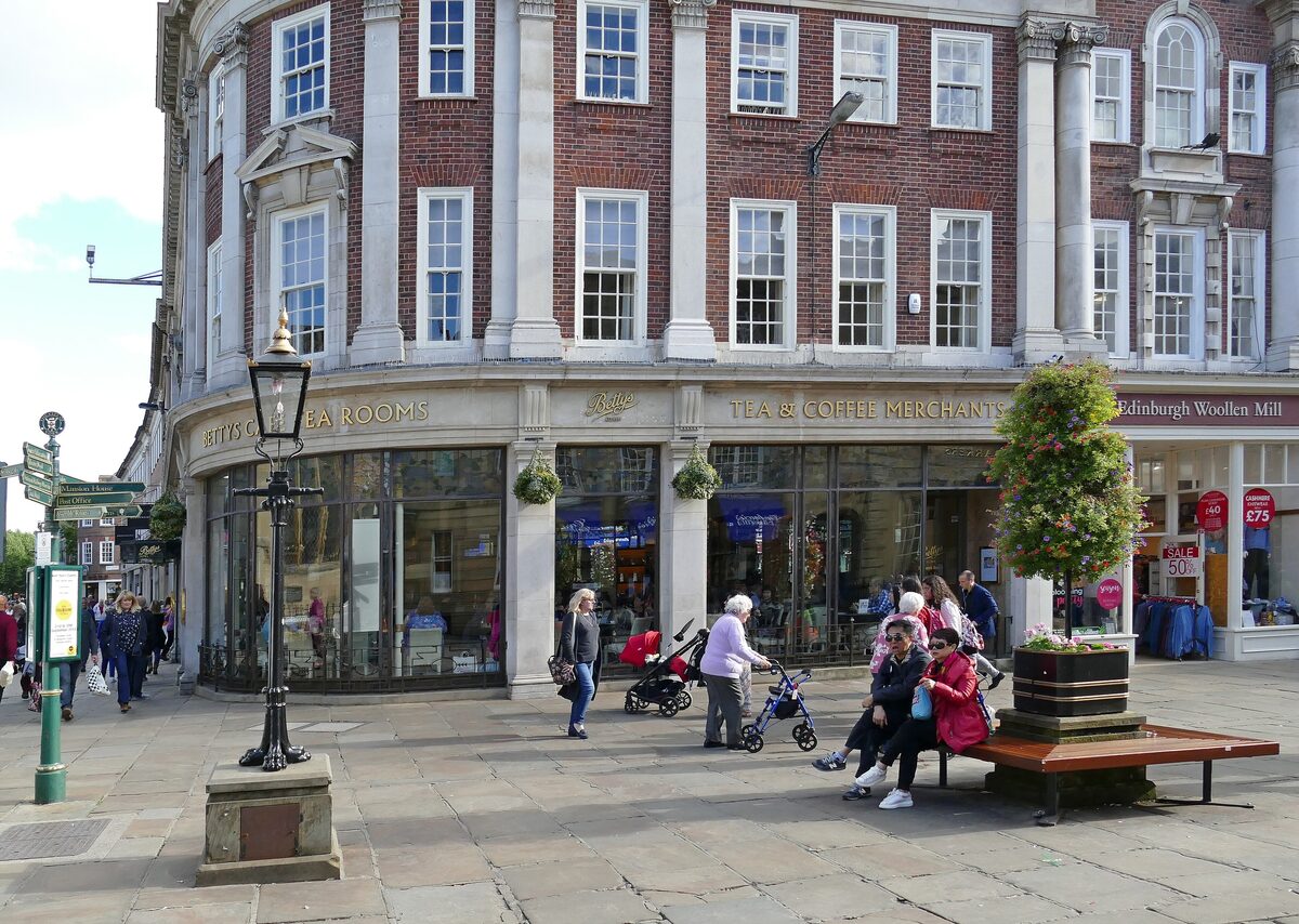 Bettys Café Tea Rooms in York, an elegant corner building with large windows and a queue outside on St Helen's Square