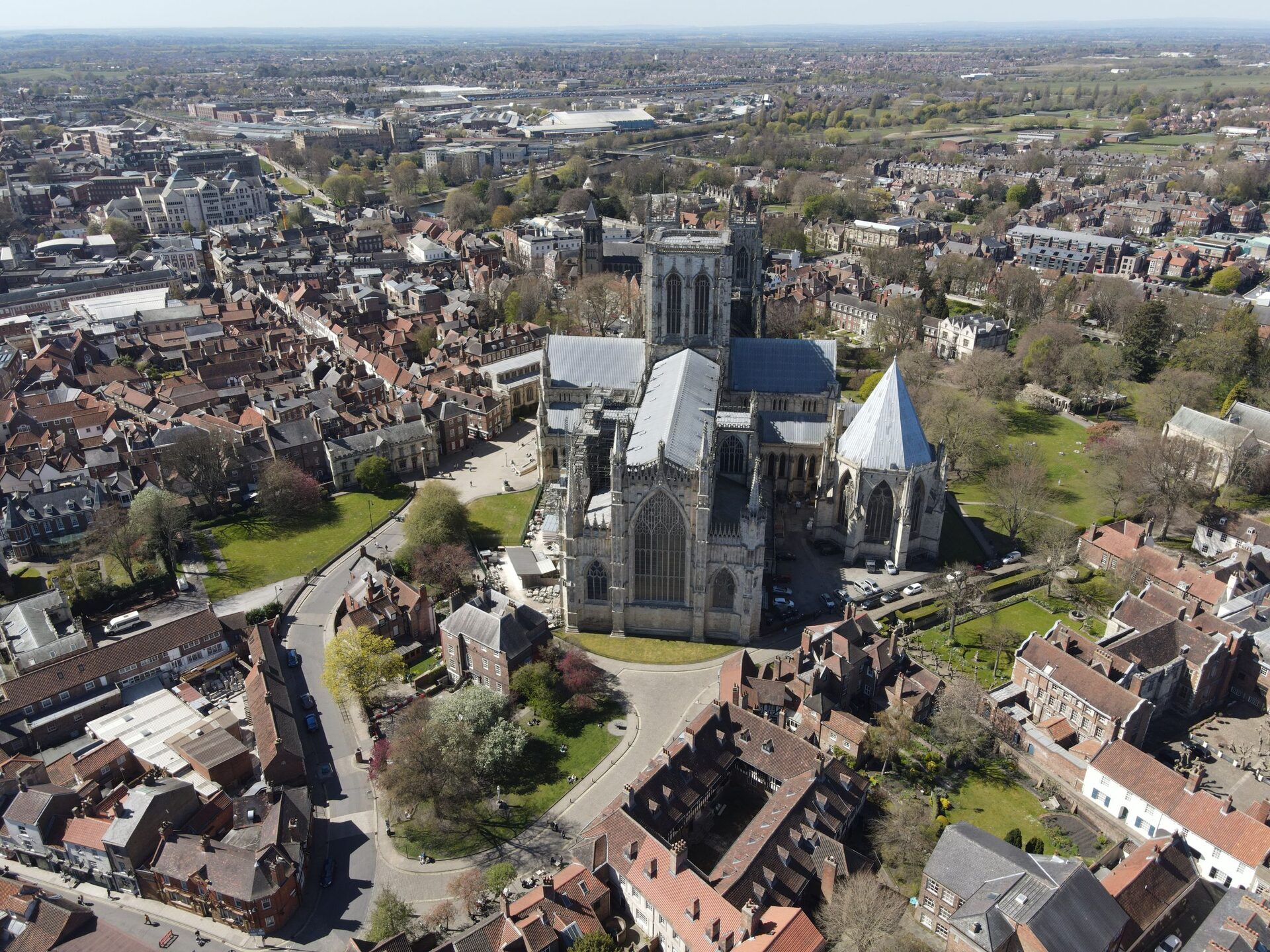 Aerial view of York Minster, its pale Gothic towers and lead roofs rising above the red-brick houses and green lawns of the old city