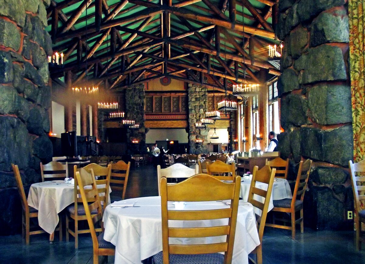 Set tables and timber beams inside the Ahwahnee dining room