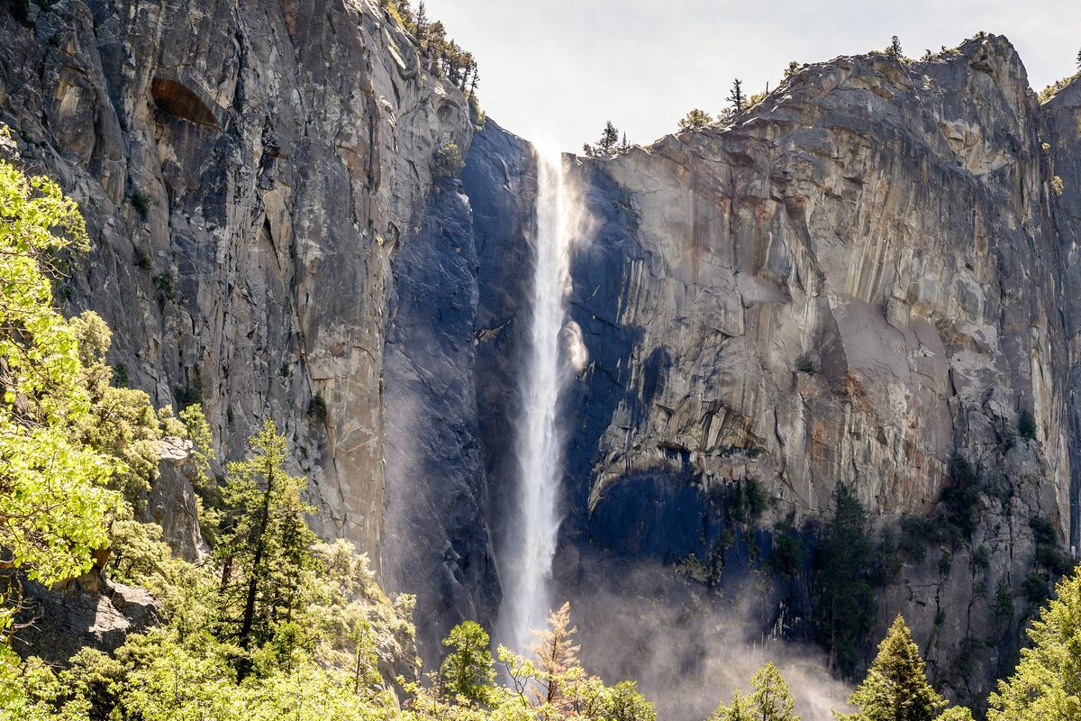 Bridalveil Fall dropping down a granite wall into a green canyon