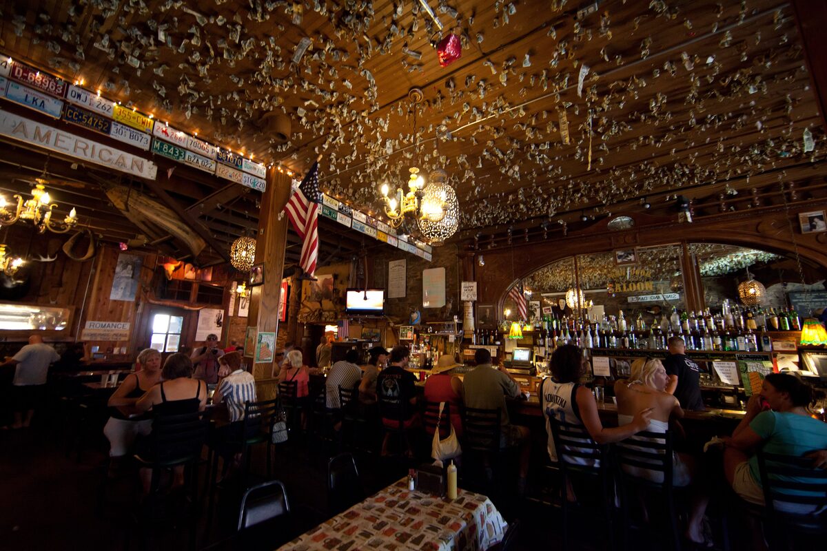 The crowded bar and cluttered ceiling inside the Iron Door Saloon