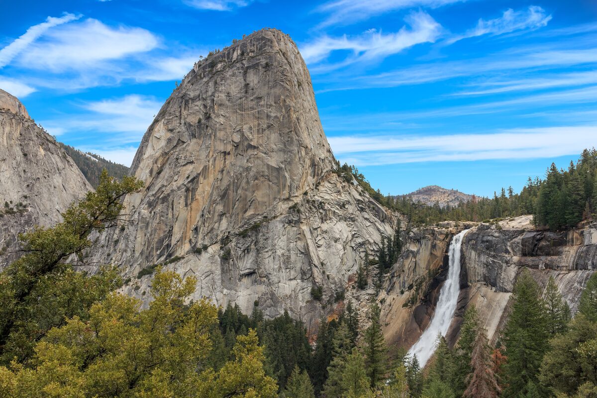 Nevada Fall plunging beside Liberty Cap under a deep blue sky