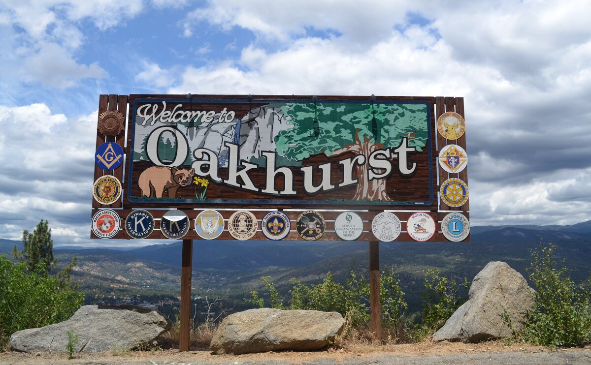 The Welcome to Oakhurst sign above the town and its valley