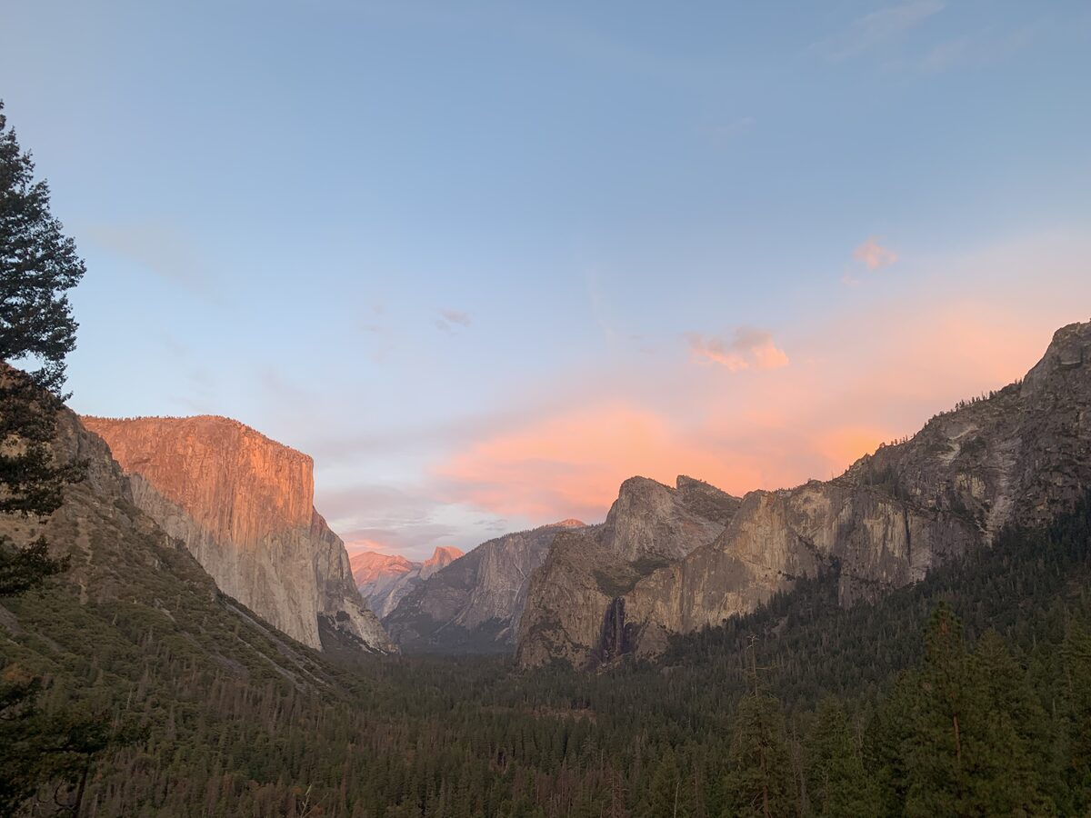 Sunset alpenglow lights El Capitan and pink clouds over Yosemite Valley