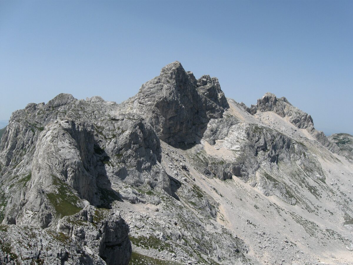 Rocky limestone peaks of the Bobotov Kuk massif seen from Minin Bogaz under a pale blue sky