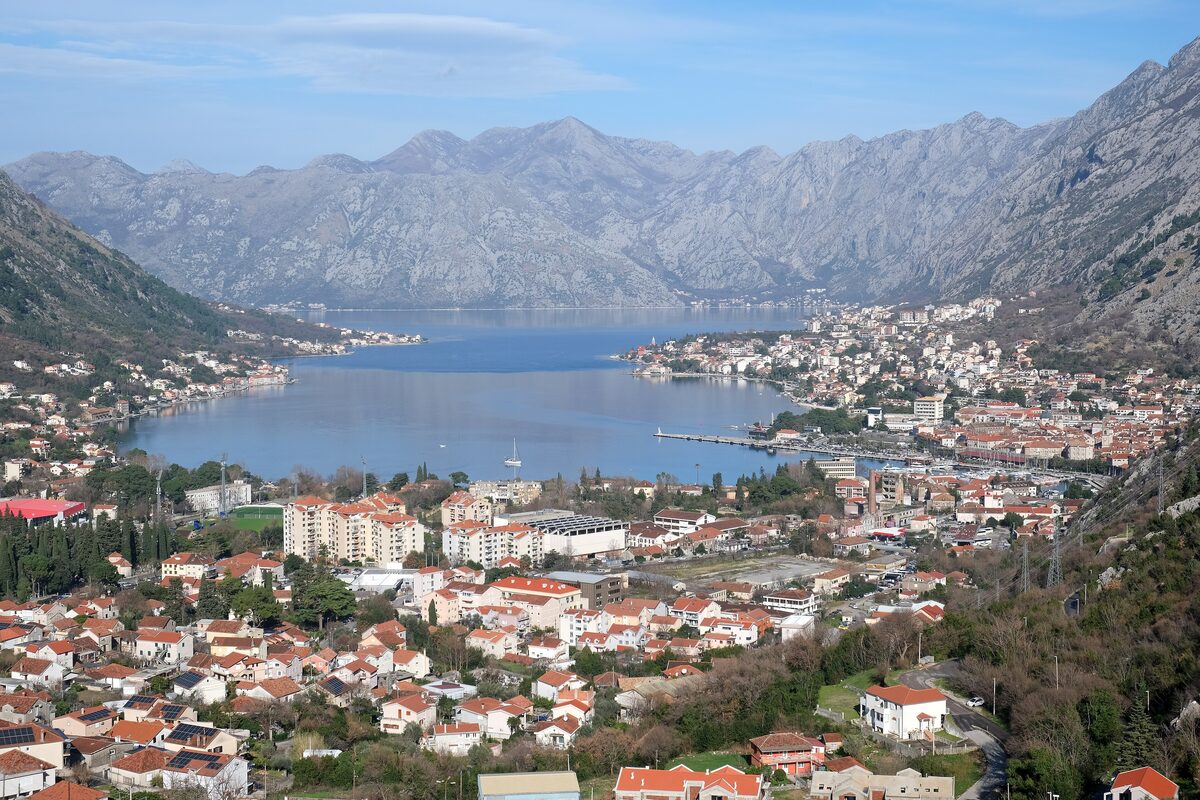 The Bay of Kotor from the hills above, with the red-roofed towns on the shore and the mountains rising behind the water