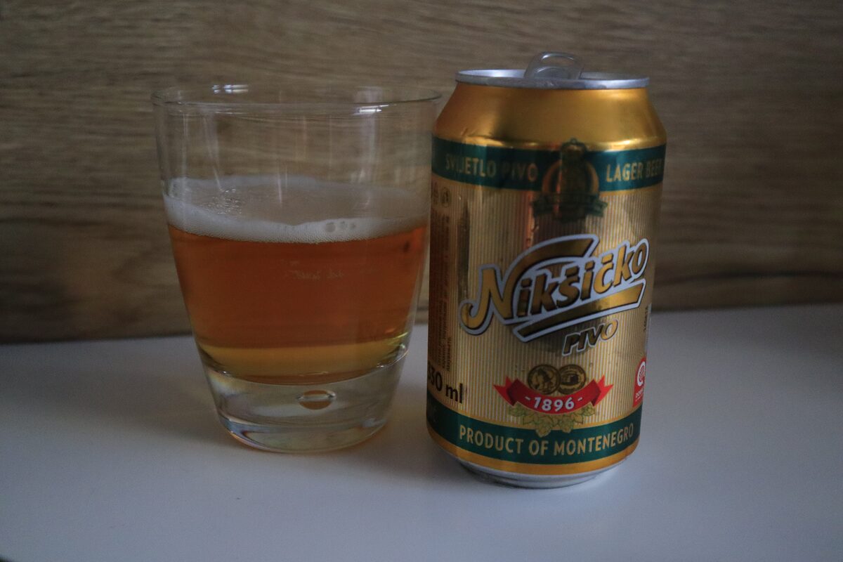 A glass of pale lager beside a can of Nikšićko beer