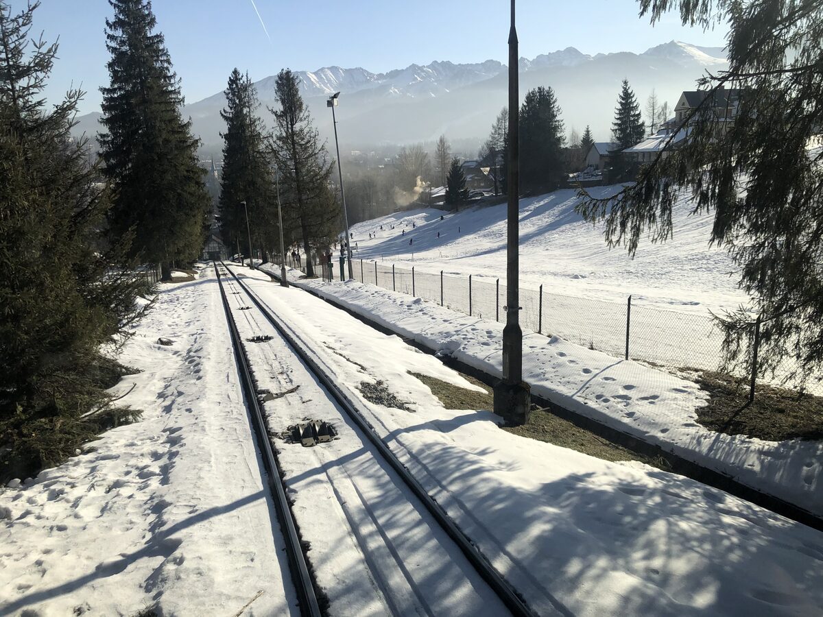 The Gubałówka funicular track running through snow, with the Tatra peaks in the distance