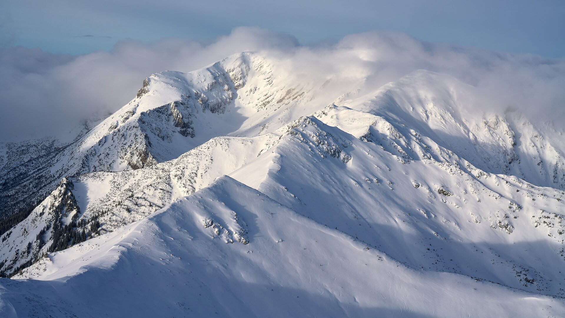 Snow-covered Tatra ridges under drifting cloud on a winter day, the Kasprowy Wierch side of the range