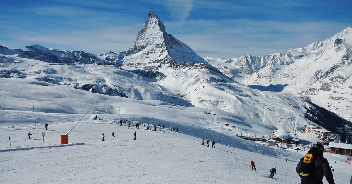 The Matterhorn above snowy pistes on the Gornergrat and Riffelberg slopes, with skiers below