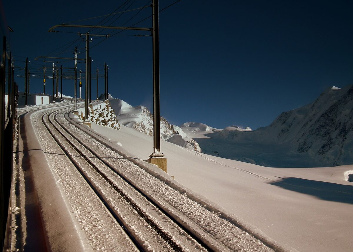Gornergrat railway tracks running through deep snow on a clear winter day