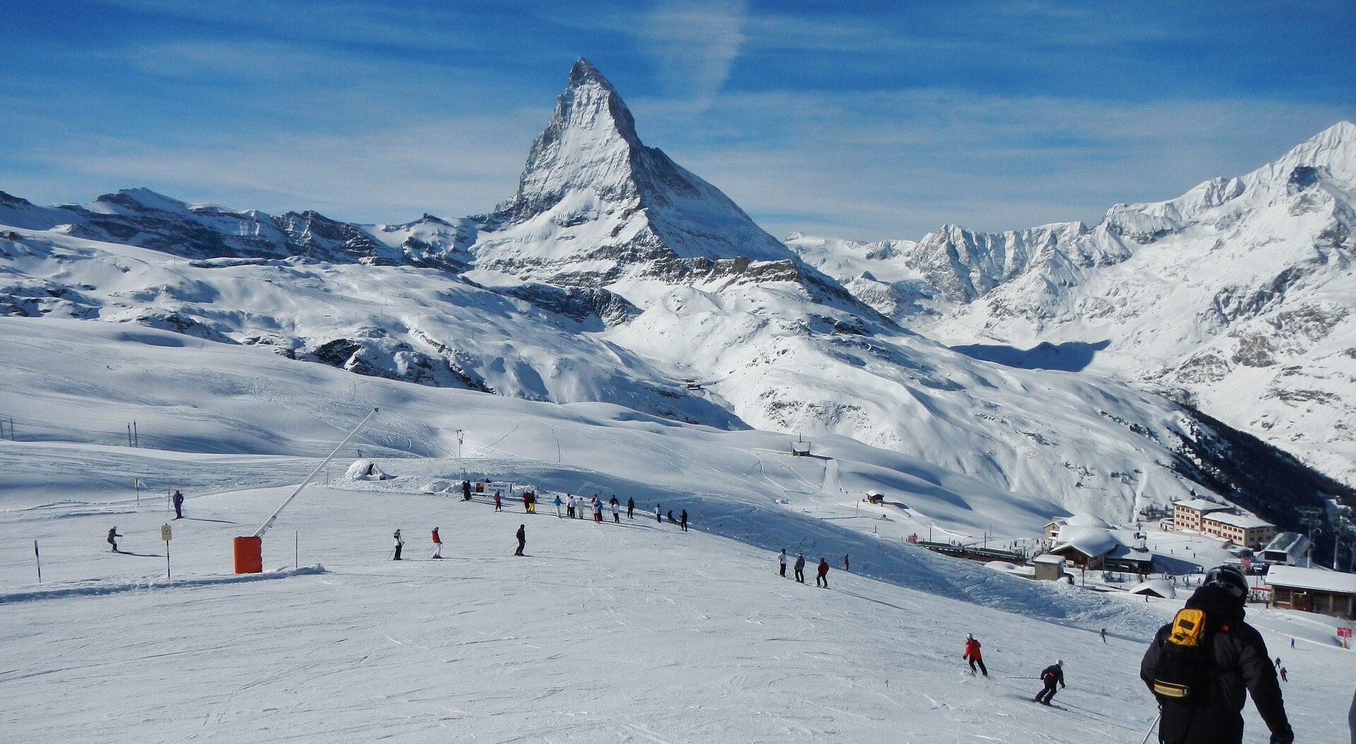 The Matterhorn above snowy pistes on the Gornergrat and Riffelberg slopes, with skiers below