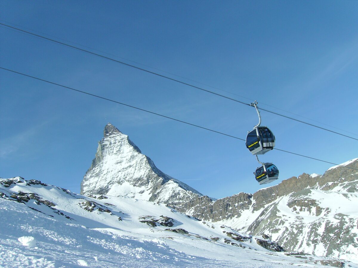 Matterhorn Express gondolas against the Matterhorn, with snow in the foreground